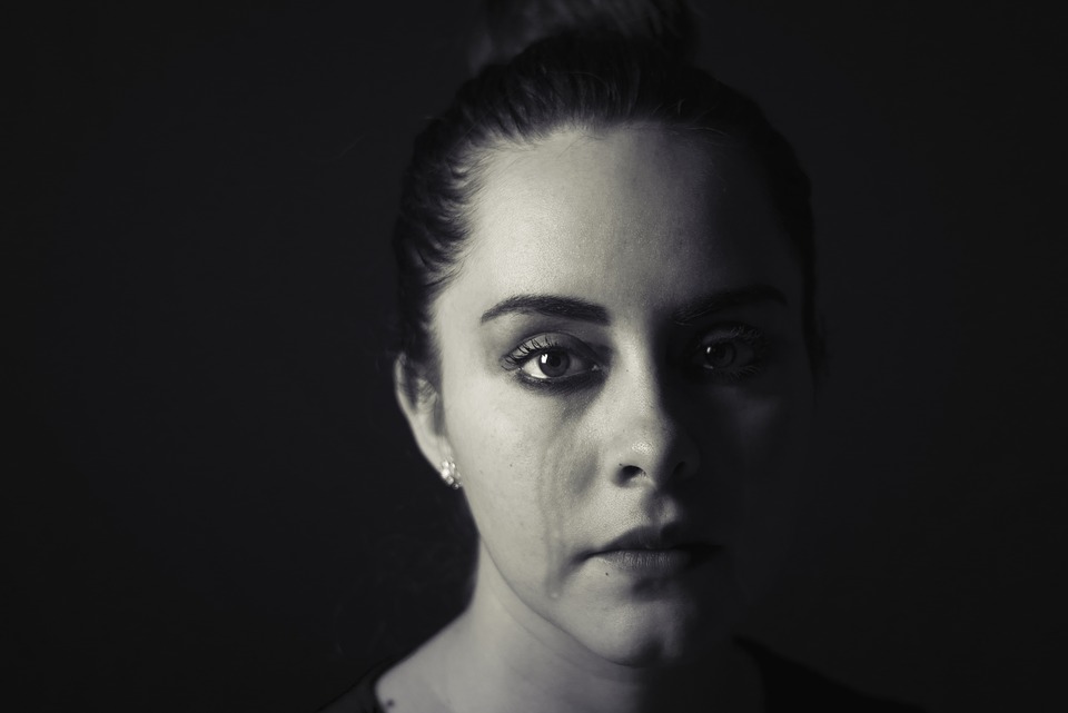 A black and white photo of a woman crying.